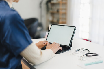 Medical professional using tablet computer with keyboard while working at desk in bright modern clinic office © PRIME STOCK LAB