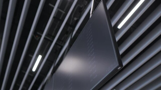 Modern ceiling with sleek, dark slats and bright linear lights. Camera pans slowly upward through geometric patterns. Clean, minimalist design emphasizes symmetry and lighting