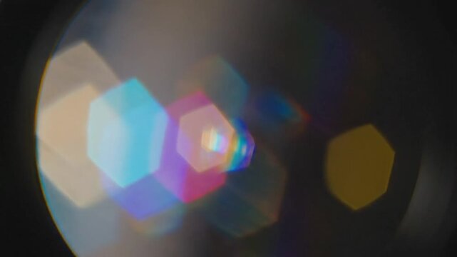 Abstract lens flare with bright colorful hexagonal bokeh lights on a dark background