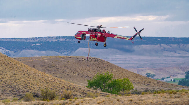 Siller Sikorsky S-64 Skycrane Firefighting Helicopter Flying Over Rugged Desert Terrain with Snorkel Deployed