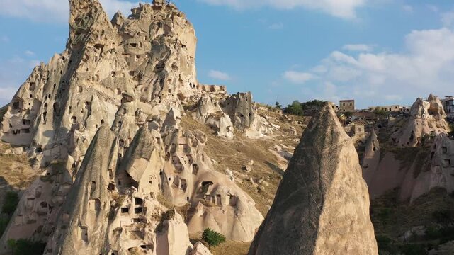 Drone aerial video of Uchisar Castle in Cappadocia, Turkey with forward movement and camera tilting upward revealing the massive rock fortress.