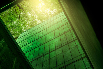 Eco-friendly building in the modern city. Sustainable glass office building with tree for reducing heat and carbon dioxide. Office building with green environment. Corporate building reduce CO2. © Fahroni