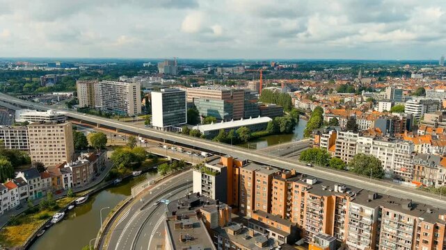 Ghent, Belgium. Esco (Scheldt) river embankment. Panorama of the city from the air. Cloudy weather, summer day. Drone footage, Departure of the camera