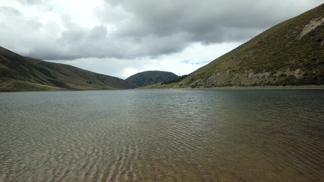 Mountain Lake With Rippled Water Under Stormy Sky