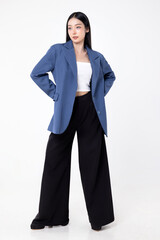 Obraz premium Confident Asian businesswoman in smart casual blazer and wide-leg trousers posing professionally isolated on white background, modern corporate lifestyle and fashion concept.
