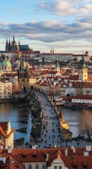 Obraz premium Panoramic view of Prague, Czech Republic, featuring Charles Bridge and Prague Castle under a beautiful sky at sunset.