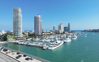 Naklejka premium Miami Beach coastal skyline with boats. Coastal cityscape of Miami Beach with yachts and harbor. Miami Beach cityscape with marina port. Aerial view of Miami Beach with marina, yachts and coastal.