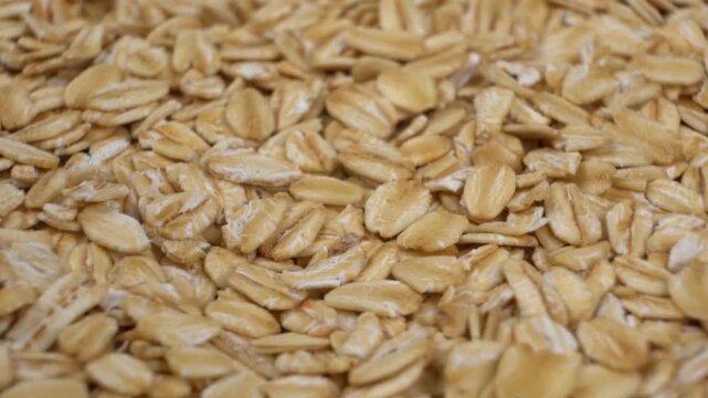 Close up macro texture background of dry raw rolled oats for breakfast food and healthy eating concept
