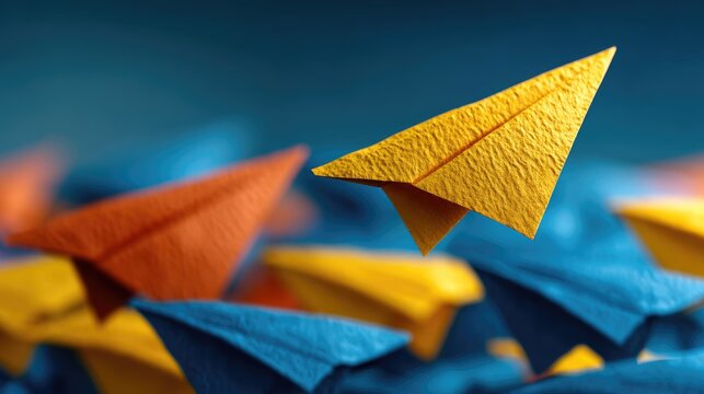 Paper plane flying among others, leadership standout concept, individuality, unique business idea, yellow and blue contrast 