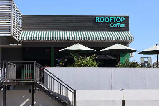 Balikpapan-Indonesia april 04, 2026 Front view of Rooftop Coffee shop with a striped awning and outdoor umbrellas under a clear blue sky at Sultan Aji Muhammad Sulaiman Airport in Balikpapan Indonesia