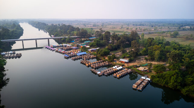 A tourist destination, a holiday retreat, a river, trees, a perfectly balanced and beautiful landscape, eco-friendly relaxation, photographed from a drone.