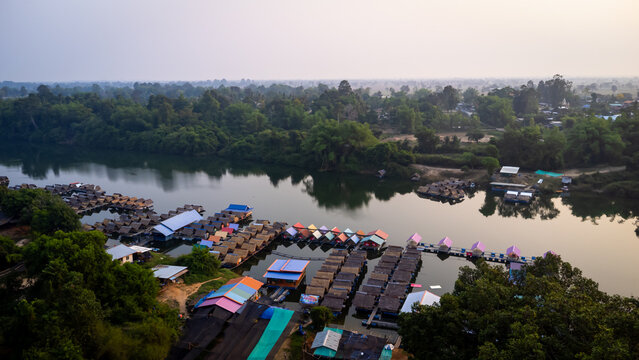 A tourist destination, a holiday retreat, a river, trees, a perfectly balanced and beautiful landscape, eco-friendly relaxation, photographed from a drone.