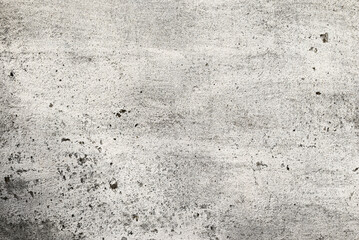 Fototapeta premium Old concrete wall with white paint. Worn surface with subtle texture, neutral grunge background for design and overlay.