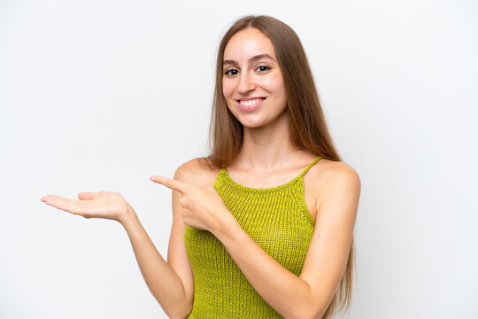Young caucasian woman isolated on white background holding copyspace imaginary on the palm to insert an ad
