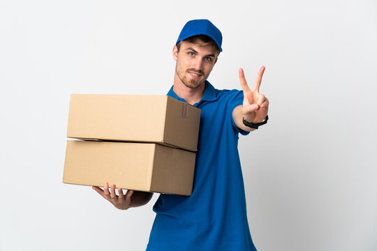 Young delivery blonde man isolated on white background smiling and showing victory sign
