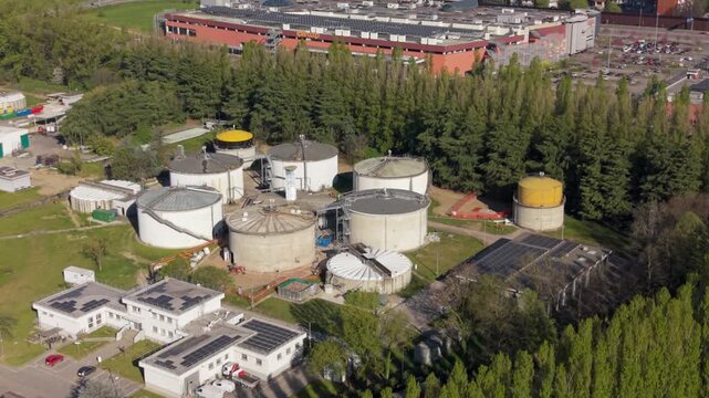 Aerial drone view of a pioneering biogas plant in Peschiera Borromeo, Italy. Anaerobic sludge generates electricity, heat, and cooling, demonstrating sustainable industrial innovation.