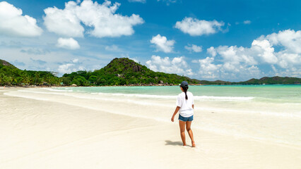 Obraz premium Breathtaking beach walk in Seychelles with stunning turquoise waters and golden sands