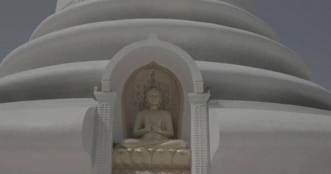 Japanese Peace Temple In Rumassala, Galle, Sri Lanka. Close up Famous landmark and cultural sacred place. The golden statue of Lord Buddha in Parinirvana, Japanese Peace Pagoda. View of the Japanese