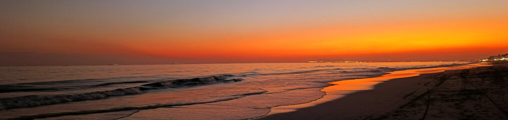 Obraz premium Orange sunset on Al Haffa beach in Salalah, Oman. Web banner with copy space