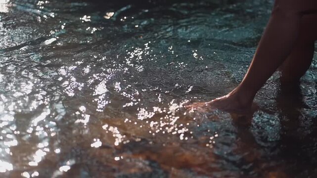 Woman barefoot legs standing in clear forest stream water, persom feet in tropical river with flowing water and natural relaxation scene 4k
