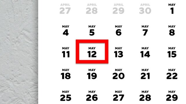 The date May 12th marked with a red cursor on the wall calendar 2026
