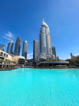 Modern luxury architecture of the Address Downtown hotel with clear blue water in the foreground, Dubai, UAE, 2025 
