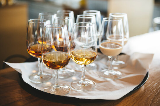 Professional tasting flight of whiskey and cream liqueur in elegant Glencairn-style glasses on a tray. Perfect for spirits sampling, distillery tours, luxury hospitality, and bar beverage service.