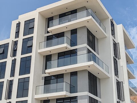 Full exterior view highlights sense of purity with modern-classic balcony designs. Multi-story building with white-colored fa&ccedil;ade, black-tinted window glass. G7-level luxurious penthouse with Terrace