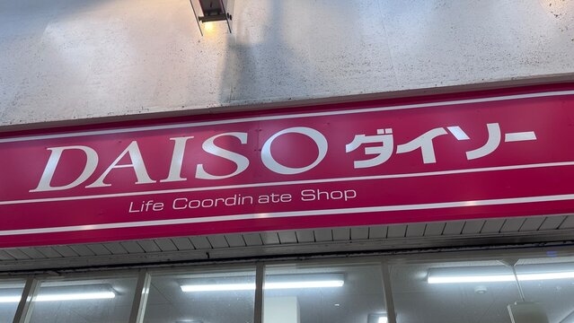 Daiso Japanese discount store storefront and logo sign with Doutor Coffee Shop visible in the neighborhood commercial district - Osaka, Japan, September 3, 2025
