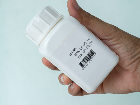 Expire drugs label check, finger woman holding bottle mfg and exp date infomation, supplement food product, blur medicine label, blur text.