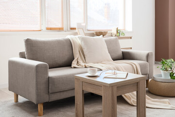Fototapeta premium Interior of stylish living room with grey sofa, coffee table and window