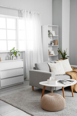 Fototapeta premium Interior of light living room with window, sofa and table