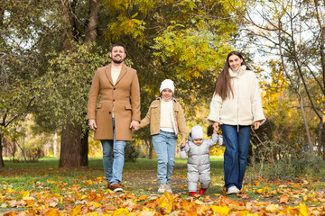 Naklejka premium Happy family walking in autumn park