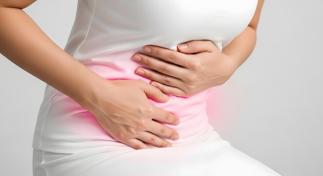 Woman holding her stomach during menstrual cramps or abdominal pain. Gynecology health and bloating symptoms. Person sitting down in physical discomfort