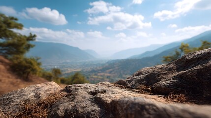Fototapeta premium A vast mountain valley stretches out under a blue sky with clouds viewed from a rocky foreground