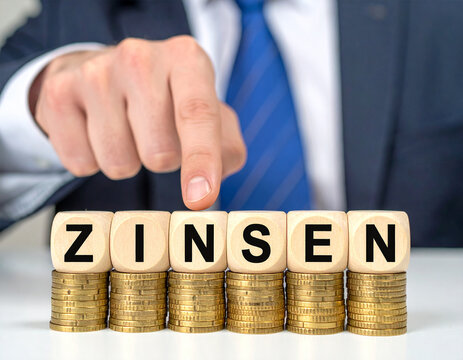 Zinsen - Geschäftsmann zeigt auf das Wort "Zinsen"