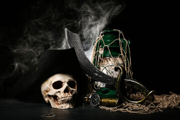 Travel equipment with oil lamp, human skull and net on black background © Pixel-Shot