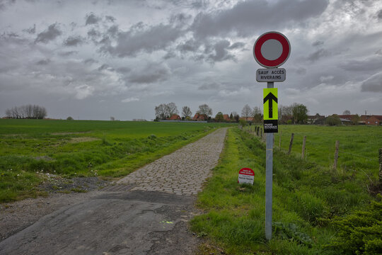 route en pav&eacute; emprunt&eacute; par la course cycliste du paris Roubaix secteur  Templeuve moulin  avec   un ciel gris mena&ccedil;ant 
