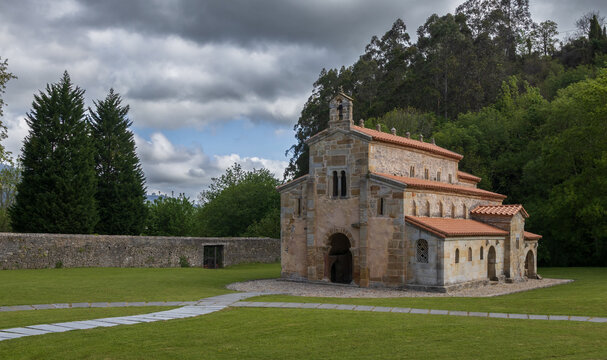 Iglesia prerrom&aacute;nica de San Salvador de Valdedi&oacute;s bajo un cielo nublado, joya del arte asturiano del siglo IX rodeada de naturaleza y murallas de piedra en el valle de Valdedi&oacute;s, Asturias, Espa&ntilde;a.
