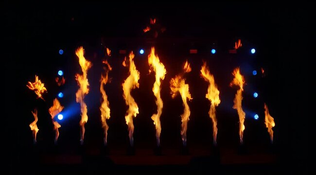 Stage performance with fire dancers and blue lights at night