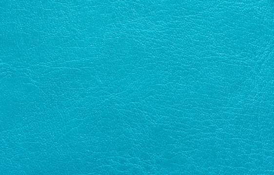 High-Angle Close-Up of Bright Turquoise Faux Leather Texture,A detailed, full-frame background of vibrant turquoise synthetic leather material. The image showcases the intricate pebbled grain pattern 