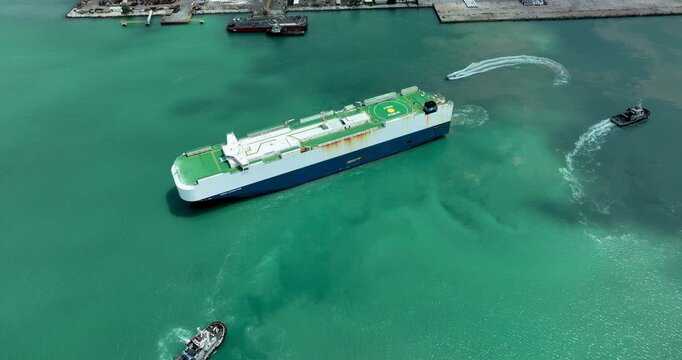 Large Commercial Vehicle Carrier Ship Maneuvering In Port With Tugboat Assistance