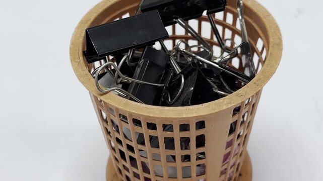 Black paper clips, in a storage container, company.