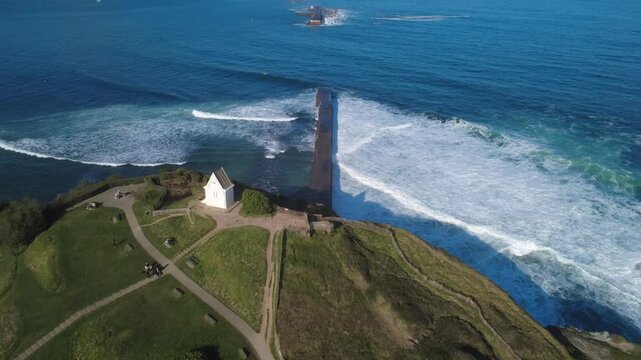 La chapelle de la sainte Barbe et la digue &agrave; Saint Jean de luz dans le Pays Basque, vue a&eacute;rienne avec travelling avant