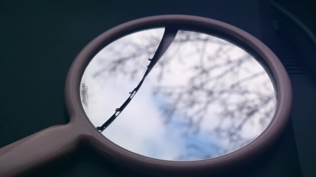 Broken hand mirror reflecting sky and tree, dreamy nostalgic footage