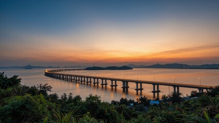 Obraz premium Long Bridge over Calm Water at Sunset with Islands and Mountains