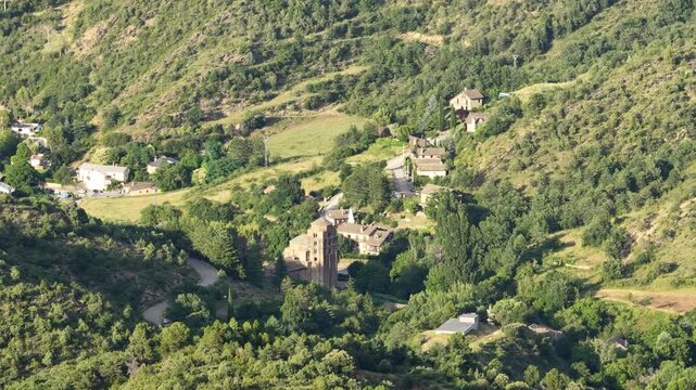 Beautiful panoramic perspective of a secluded European hamlet with a historic church nestled among lush green trees and rolling hills