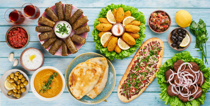 Turkish food background with pide, kofte, lentil soup, mezze, dolma, flatbread on table colorful traditional assortment