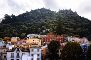Obraz premium Scenic view of Sintra, Portugal, with colorful buildings and a castle on a hilltop.