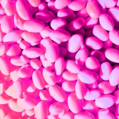 Obraz premium Neon pink beans abstract background, Vibrant fuchsia colored soybeans, Creative pop art food texture, Surreal pink legume seeds.